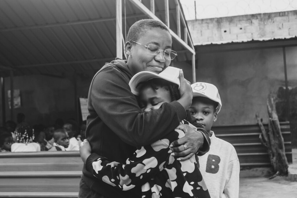 A touching moment of family love and connection, embracing in a serene outdoor setting.