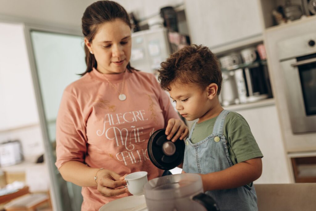 Mother and son enjoying kitchen time, pouring beverage together.