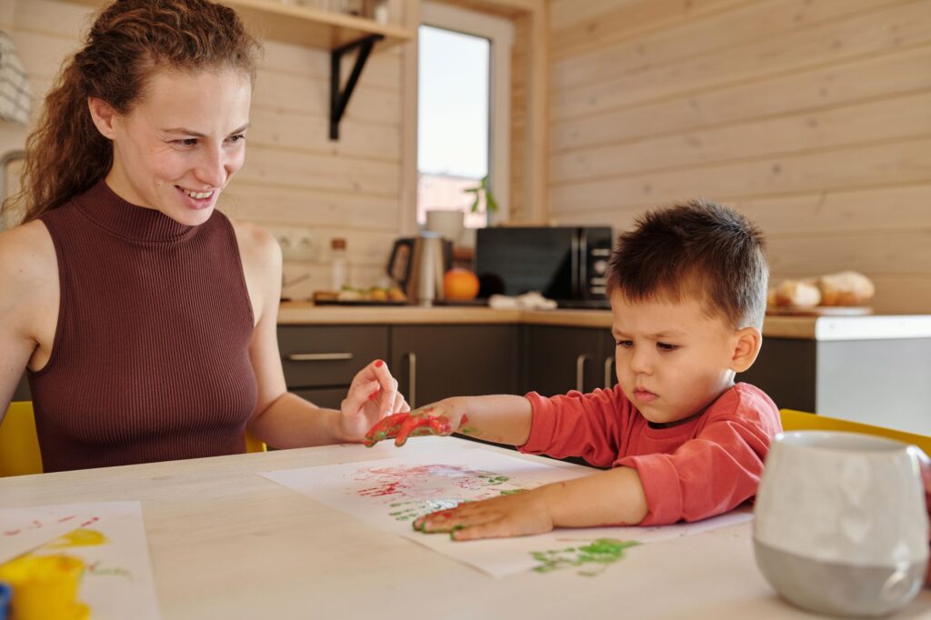 Mother and child enjoying a painting session at home, fostering creativity and bonding.