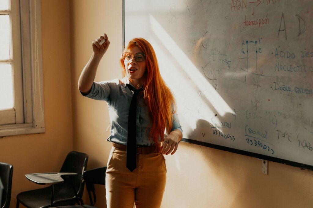 A teacher explaining a concept at a whiteboard. Bright classroom setting in Buenos Aires, Argentina.