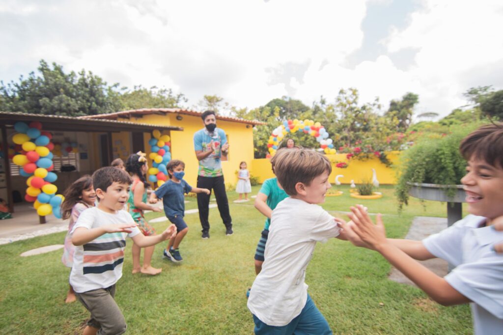 Joyful scene of children playing outdoors in a festive, colorful birthday party setting.