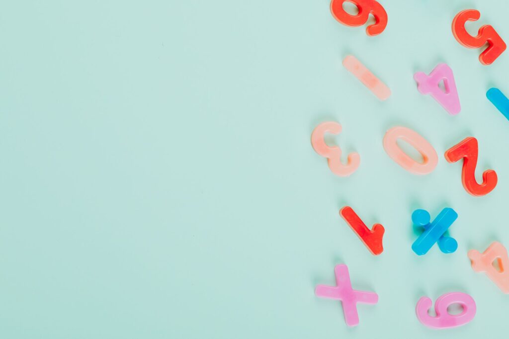 Vibrant plastic numbers arranged on a light teal backdrop with ample copy space.