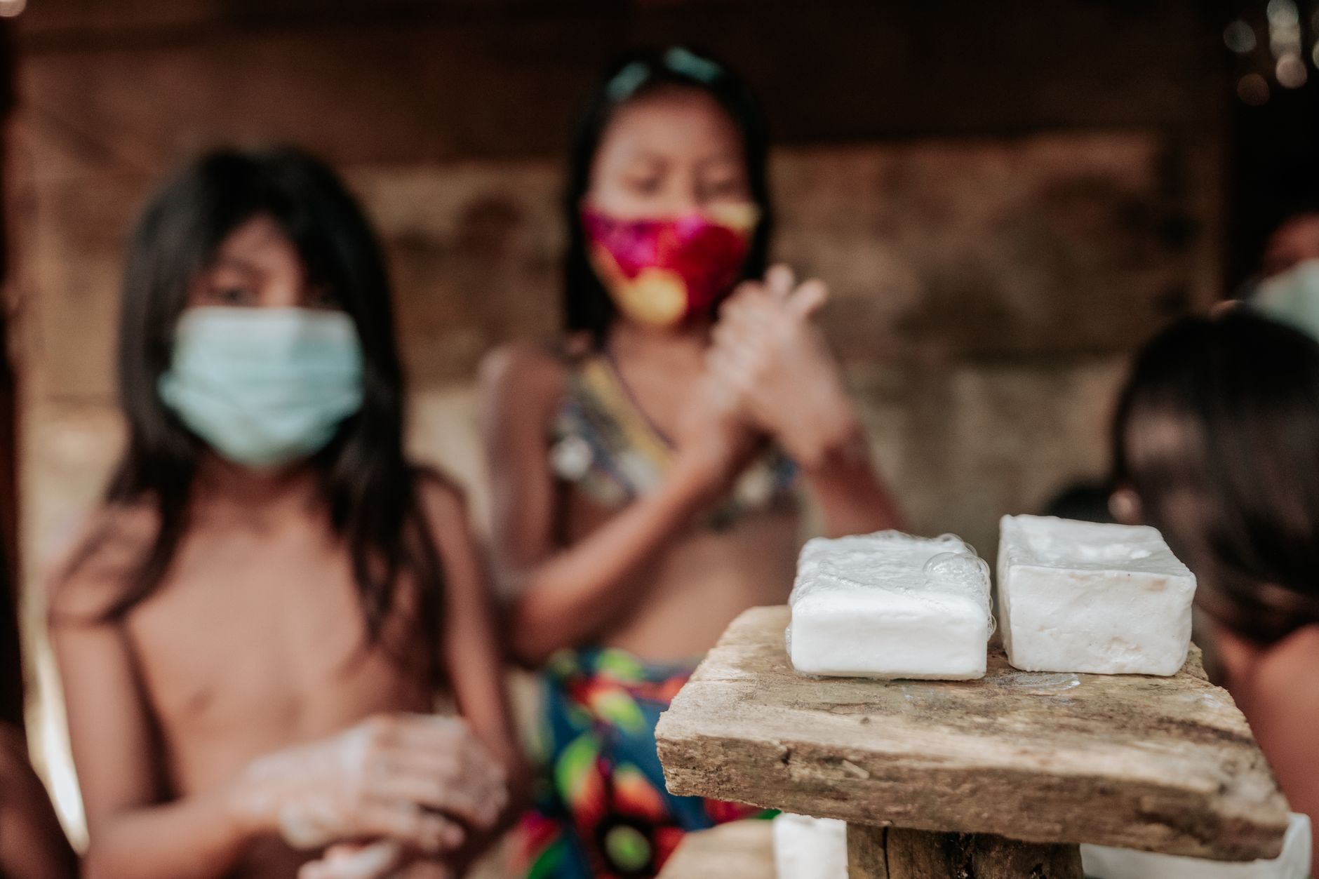 Children washing hands with soap outdoors, highlighting hygiene and community.