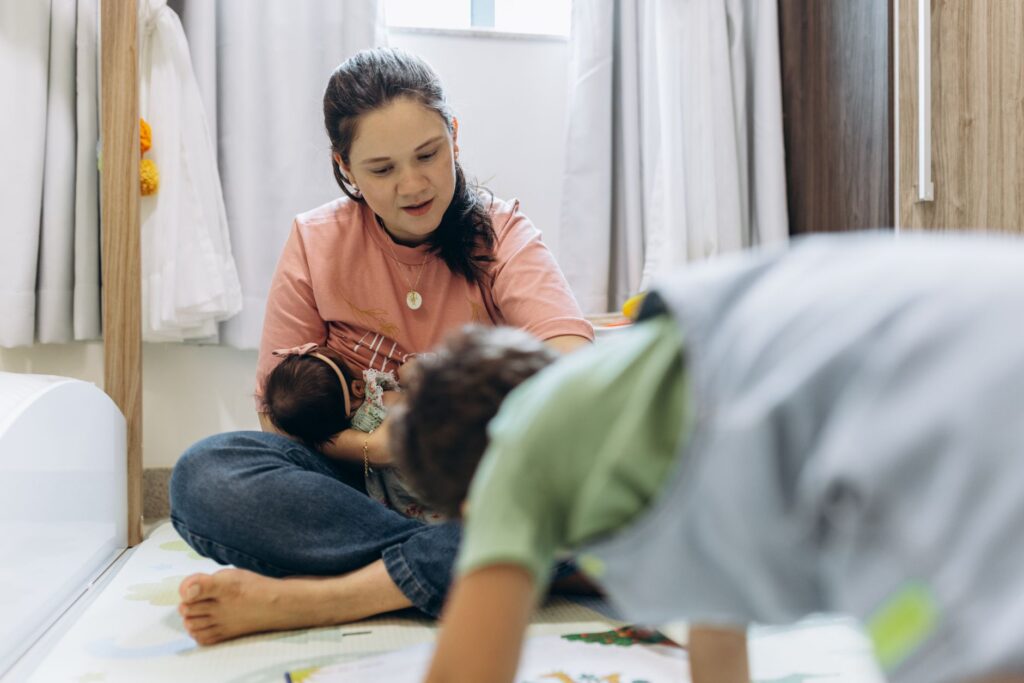 A mother enjoying playtime with her children at home in a cozy room setting.