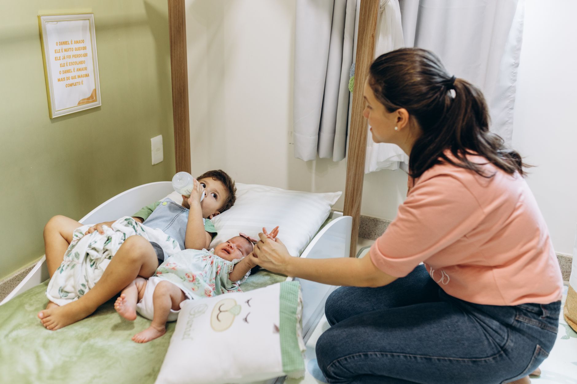 A mother sits with her children on a bed, fostering a warm and nurturing atmosphere.