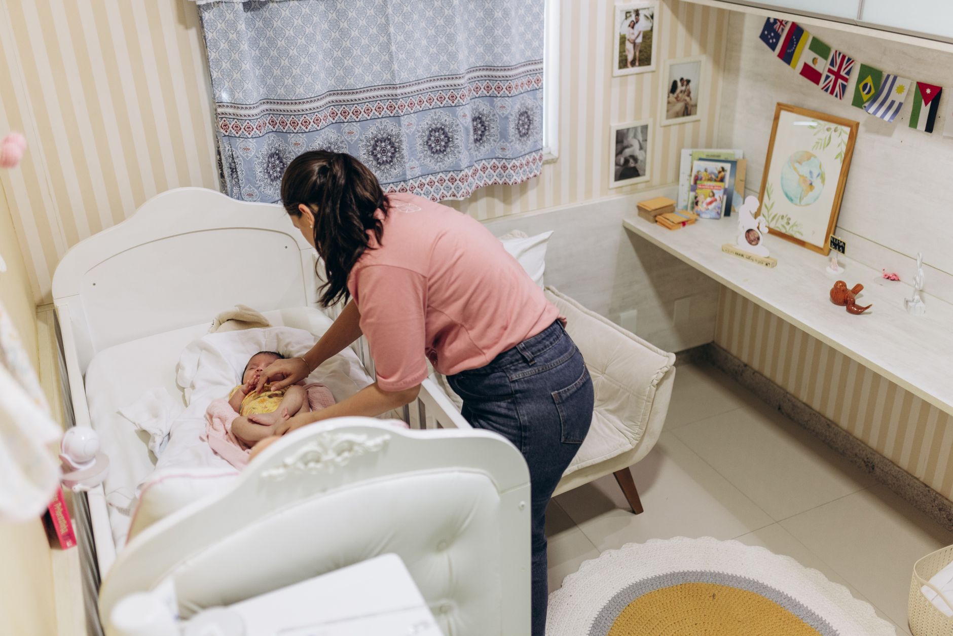A mother tends to her baby in a cozy nursery, capturing a tender moment.