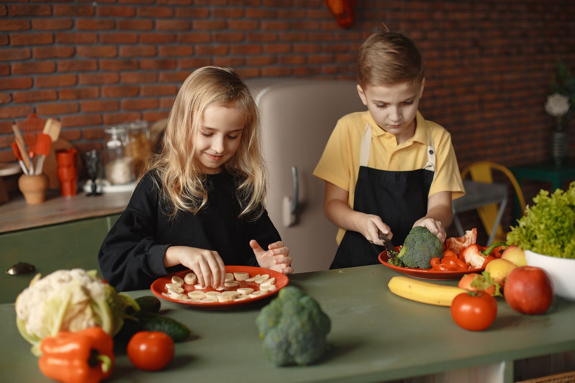 Two kids having fun preparing a healthy meal with fresh ingredients indoors.