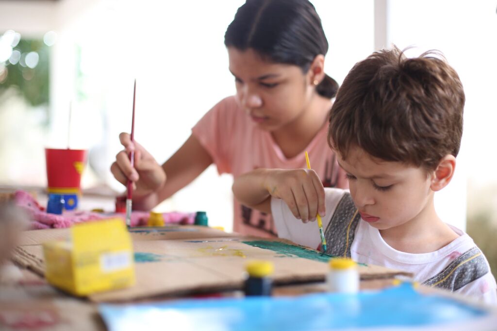 Young boy and girl painting together, fostering creativity and collaboration.