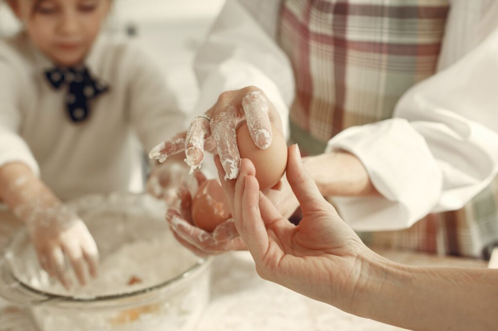 A close-up of hands preparing dough, emphasizing family teamwork.
