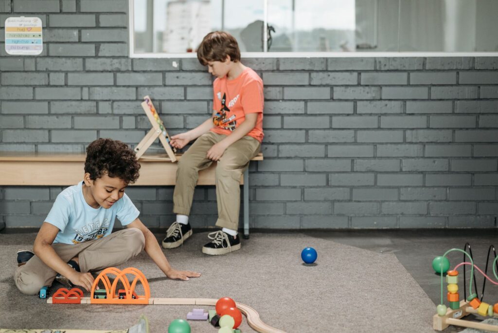 Two boys engaged with educational toys in a kindergarten classroom setting.