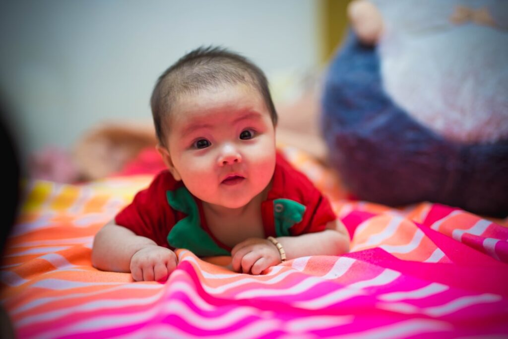 Bebe Na Camisa Verde Deitado Na Cama De Listras Rosa E Branca EahTndPDN1M