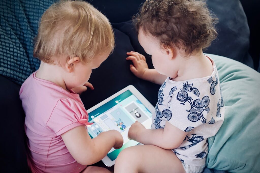 Duas Criancas Sentadas No Sofa Enquanto Usam O Computador Tablet ChuzevDl4qM