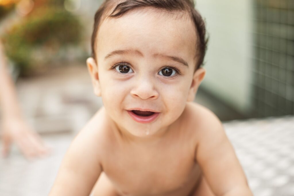 Close-up portrait of a joyful baby with a captivating smile, exuding warmth and innocence.